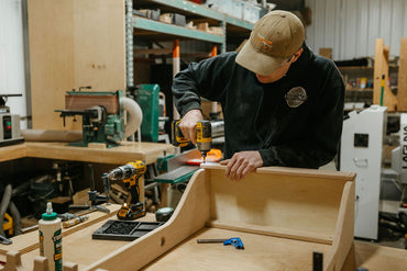 Woodworker assembles wood handcrafted vertical gun rack