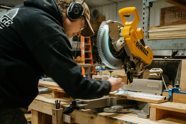In a woodshop a wood worker uses a dewlap saw to cut oak boards